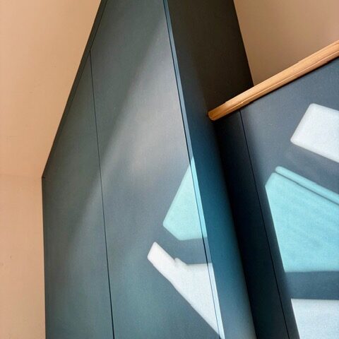 Placard bleu sur mesure épousant la pente du toit — aménagement intérieur Wood&C